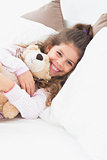 Little girl cuddling teddy bear