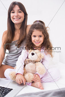 Smiling daughter and mother with laptop