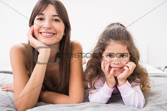 Mother and daughter smiling in bed