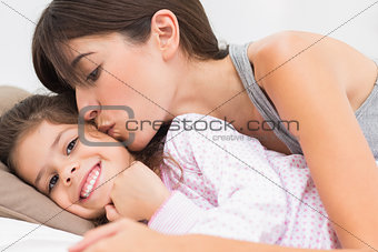 Mother kissing happy daughter on the cheek