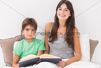 Happy mother and son reading book