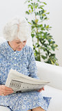 Elderly cheerful woman reading newspapers