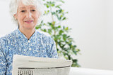 Elderly calm woman reading newspapers