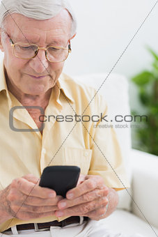 Focused elderly man using his smartphone