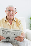 Smiling elderly man reading the news
