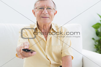 Smiling elderly man using the remote