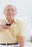 Cheerful elderly man using the remote