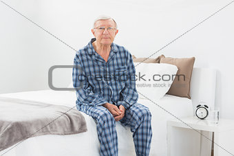 Aged man sitting on his bed