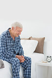 Calm elderly man sitting on the bed