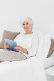 Cheerful elderly woman using a digital tablet