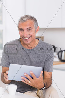 Smiling man using his digital tablet