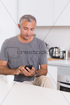 Mature man touching his smartphone