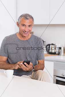 Smiling man touching his smartphone