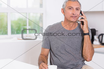 Man drinking while phoning