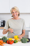 Mature woman cutting a yellow pepper
