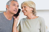 Happy mature couple listening a call together