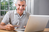 Smiling mature man using his laptop