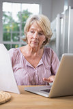 Focused mature woman using her laptop
