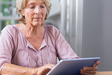 Mature woman touching her digital tablet