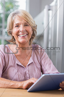 Happy mature woman using her digital tablet