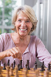 Happy woman playing chess