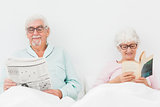 Happy couple reading in bed