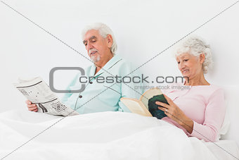 Smiling couple reading in bed
