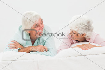 Happy couple looking at each other in bed