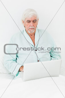 Man with laptop in bed