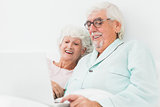 Couple watching something on laptop in bed