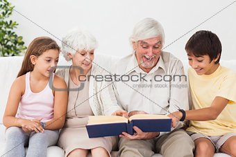 Grandparents reading book with grandchlidren