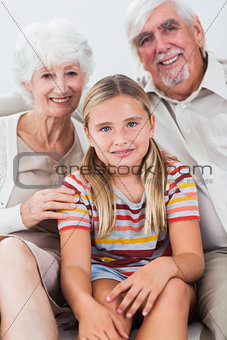 Granddaughter with grandparents on the sofa