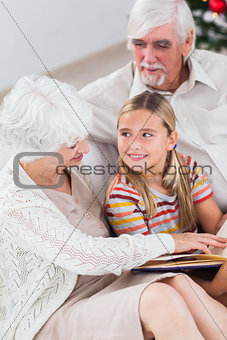 Grandparents with granddaughter reading