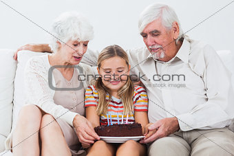 Little girl with grandparents celebrating birthday