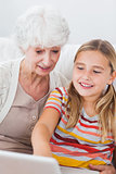 Little girl and granny using laptop
