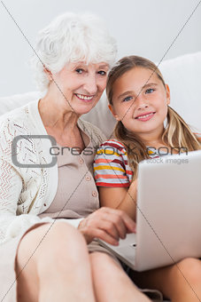 Happy girl using laptop with granny