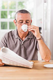 Man reading newspaper and drinking espresso