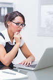 Girl working on her computer with pair of glasses