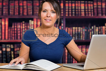 Woman using a computer and book