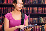 Girl touching a tablet in library