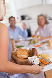 Woman bringing the turkey to the dinner table