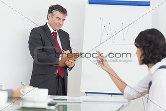 Businessman writing on clipboard in office