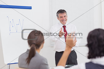 Businessman pointing to colleague raising her hand with big smile