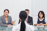 Three business people folding hands in small meeting