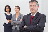 Businessman and his team standing with crossed arms