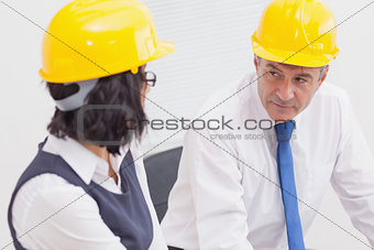 Two architects speaking with yellow helmet