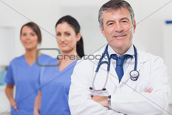 Doctor with stethoscope smiling and his team