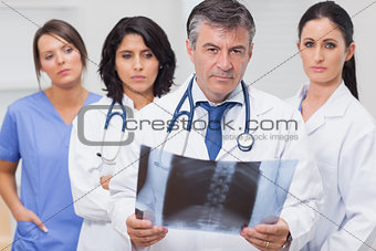 Doctor holding xray with his team