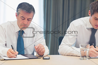 Businessmen taking notes