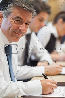 Happy businessman taking notes